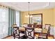 Bright dining room with elegant chandelier, wainscoting, and large windows at 450 Hammersmith Dr, Suwanee, GA 30024