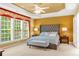 Spacious main bedroom featuring a tray ceiling, large windows, and an upholstered headboard at 450 Hammersmith Dr, Suwanee, GA 30024