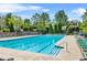 Community pool with many chairs surrounded by trees and blue skies at 450 Hammersmith Dr, Suwanee, GA 30024