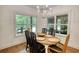 A stylish dining room features natural light, wood floors and a modern chandelier over the wood table at 60 Browning Shoals Rd, Social Circle, GA 30025