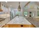 Open kitchen with a large granite island, stainless steel appliances, and access to the dining area at 60 Browning Shoals Rd, Social Circle, GA 30025