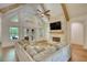 Inviting living room featuring vaulted ceilings, exposed wood beams, and a cozy brick fireplace with a mounted TV at 60 Browning Shoals Rd, Social Circle, GA 30025