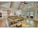 Open-concept living room with a modern kitchen, vaulted ceilings, wood beams, and a cozy sofa for relaxation at 60 Browning Shoals Rd, Social Circle, GA 30025