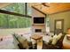 Outdoor living room with brick fireplace, beamed ceiling, and views of the spacious backyard at 60 Browning Shoals Rd, Social Circle, GA 30025