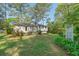 Backyard of a home with mature trees, green grass, and manicured bushes, providing a private outdoor space at 723 Monticello Se Way, Marietta, GA 30067