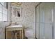 Vintage bathroom featuring patterned wallpaper, a single sink vanity, and a shower with glass doors at 723 Monticello Se Way, Marietta, GA 30067