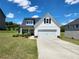 Inviting home featuring a well-manicured lawn and a spacious driveway under a bright sky at 1132 Red Bud Cir, Villa Rica, GA 30180
