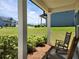 Inviting porch with rocking chairs offering a view of the landscaped yard and neighboring houses at 1132 Red Bud Cir, Villa Rica, GA 30180