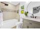 Serene bathroom featuring a tub, sleek fixtures, neutral tiles, and a circular mirror at 1554 Cardinal Rd, Jonesboro, GA 30238