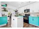 Bright kitchen with white island and teal lower cabinets and stainless steel appliances at 1554 Cardinal Rd, Jonesboro, GA 30238
