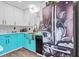 Close up shot of a refrigerator and sink featuring teal and white cabinets and a dark countertop at 1554 Cardinal Rd, Jonesboro, GA 30238