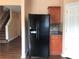 Kitchen features a black refrigerator and wood cabinets with granite countertops and is adjacent to the stairwell at 1938 Dilcrest Dr, Duluth, GA 30096