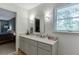 Bright bathroom with vanity, mirror, and natural light, plus a view into an adjacent bedroom at 3460 Wycherly Ne Ct, Brookhaven, GA 30319