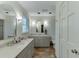 Bright bathroom with double sinks, tiled floors, and a white door with natural light from the window at 3460 Wycherly Ne Ct, Brookhaven, GA 30319
