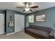 Cozy bedroom with gray walls, ceiling fan, and natural light with a guitar hanging on the wall at 3460 Wycherly Ne Ct, Brookhaven, GA 30319