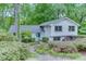 Charming two-story home with a light blue door and beautifully landscaped front yard surrounded by lush green trees at 3460 Wycherly Ne Ct, Brookhaven, GA 30319