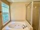 Modern bathroom featuring a large bathtub with jets and a separate glass-enclosed shower at 3650 Deep Cove Dr, Cumming, GA 30041