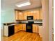 Well-lit kitchen with stainless steel appliances, light wood cabinets, and black countertop at 3650 Deep Cove Dr, Cumming, GA 30041