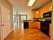 Eat-in kitchen with black appliances and hardwood floors at 3650 Deep Cove Dr, Cumming, GA 30041