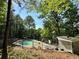 Backyard view of a sparkling fenced in swimming pool with lounge furniture, perfect for relaxation and entertainment at 3650 Deep Cove Dr, Cumming, GA 30041