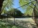 Tennis court framed by chainlink fencing and lush greenery, perfect for recreation and exercise at 3650 Deep Cove Dr, Cumming, GA 30041