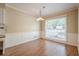 Cozy dining room features wainscotting, a large window and modern chandelier at 554 Cana Of Galilee Ct, Tucker, GA 30084