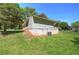 View of the home's siding and backyard lawn with large trees surrounding the property at 899 Marshall Fuller Rd, Dallas, GA 30157