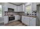 Updated kitchen boasts white cabinets, stainless steel appliances, and stylish backsplash at 899 Marshall Fuller Rd, Dallas, GA 30157
