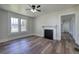 Spacious living room featuring modern wood floors, a cozy fireplace, and ample natural light from large windows at 899 Marshall Fuller Rd, Dallas, GA 30157