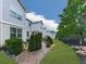 View of backyard and brick pathway between homes with green grass and landscaping at 130 Maple Creek Way, Woodstock, GA 30188