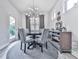 Dining area with modern light fixture, round table, and bright windows overlooking greenery at 130 Maple Creek Way, Woodstock, GA 30188
