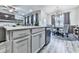Bright and airy living space featuring an open floor plan with kitchen island and modern lighting fixtures at 130 Maple Creek Way, Woodstock, GA 30188