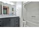 Bathroom with white tiled shower and vanity with gray cabinet at 2302 Colonial Ne Dr, Brookhaven, GA 30319