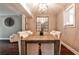 Charming dining room with rustic table, modern light fixture and view into kitchen at 2302 Colonial Ne Dr, Brookhaven, GA 30319