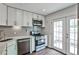 Well-lit kitchen with stainless steel appliances, subway backsplash and french doors at 2302 Colonial Ne Dr, Brookhaven, GA 30319