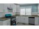 Well-lit kitchen featuring modern appliances, granite countertops, and white cabinetry at 4175 Danforth Sw Rd, Atlanta, GA 30331