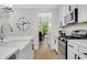 Bright kitchen featuring white cabinets, stainless steel appliances, a farmhouse sink, and stylish fixtures at 4240 Spring Ridge Dr, Cumming, GA 30028