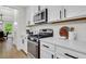 Close up view of a modern kitchen with white cabinets, granite countertops, and stainless steel appliances at 4240 Spring Ridge Dr, Cumming, GA 30028