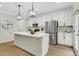 Well-lit kitchen with stainless steel appliances, granite counters, large island, and pendant lighting at 4240 Spring Rdg, Cumming, GA 30028