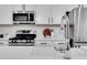 Modern kitchen showcasing white cabinetry, stainless steel appliances, a farmhouse sink and tiled backsplash at 4240 Spring Ridge Dr, Cumming, GA 30028