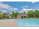 Community pool with a tanning ledge and chairs surrounded by houses and trees at 4240 Spring Ridge Dr, Cumming, GA 30028
