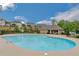 Large community pool with a tanning ledge, umbrella stand, and a surrounding deck with lounge chairs and umbrellas at 4240 Spring Rdg, Cumming, GA 30028