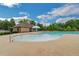 Community pool with a zero entry point, and surrounding deck with chairs and landscaping at 4240 Spring Ridge Dr, Cumming, GA 30028