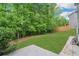 Spacious backyard with lush green lawn, mature trees, and a charming wooded area for exploring at 4240 Spring Ridge Dr, Cumming, GA 30028