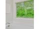 Bright bathroom featuring a white soaking tub and a forest view at 4240 Spring Ridge Dr, Cumming, GA 30028