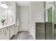 Modern bathroom featuring double sinks, a glass shower, and wood-style tile flooring at 4240 Spring Ridge Dr, Cumming, GA 30028