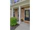 Inviting front porch with brick facade, black door, and potted flowers at 4240 Spring Ridge Dr, Cumming, GA 30028