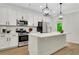 A modern kitchen featuring white cabinets, countertops, an island, and stainless steel appliances at 4240 Spring Ridge Dr, Cumming, GA 30028
