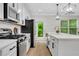 Bright kitchen with white cabinets, stainless steel appliances, and hardwood floors at 4240 Spring Ridge Dr, Cumming, GA 30028