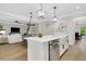 Open concept with kitchen island flowing to the living room, pendant lighting, and hardwood floors at 4240 Spring Ridge Dr, Cumming, GA 30028